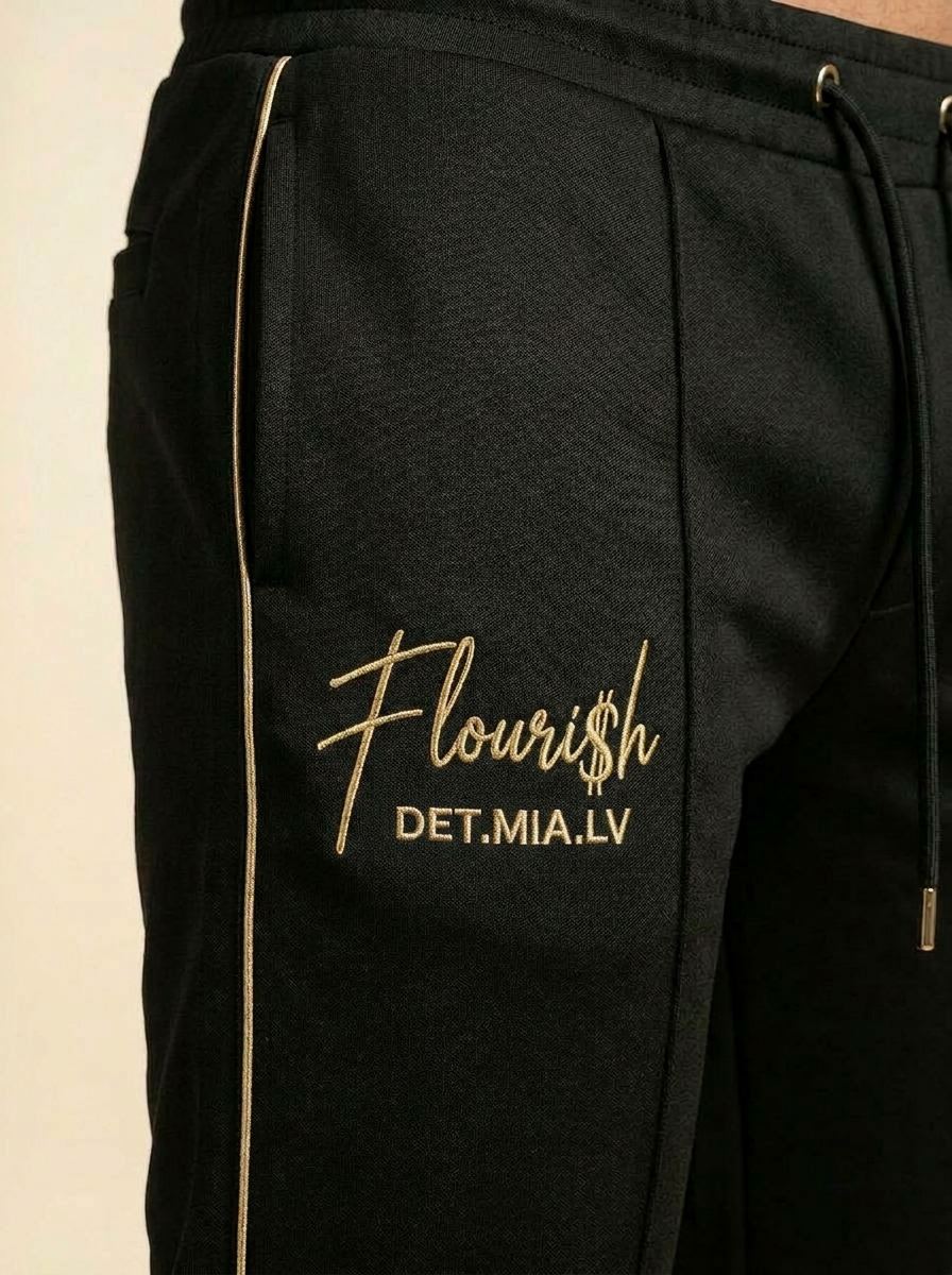 Detail of the gold side piping and Flouri$h hip embroidery on the track pant