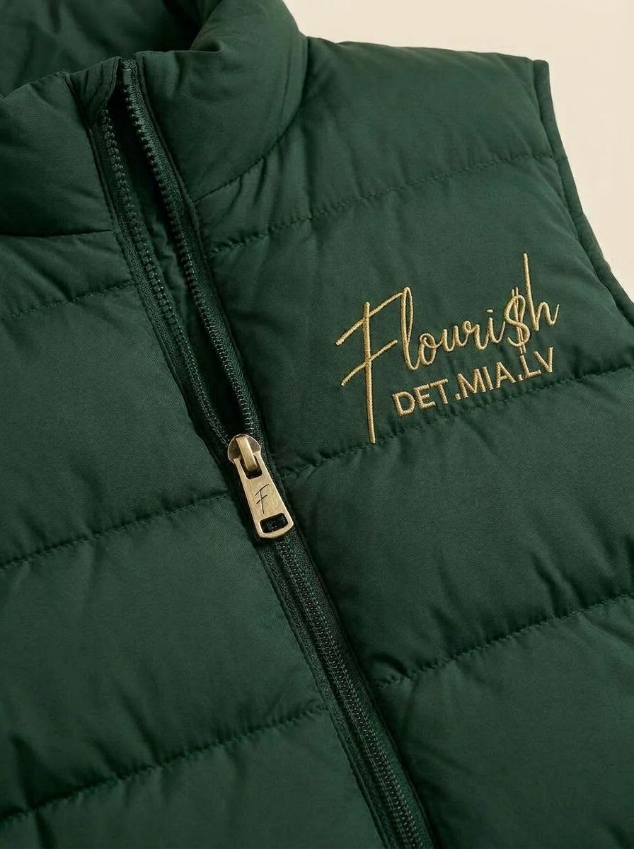 Detail of the Flouri$h Puffer Vest quilted baffles, zipper pull, and gold chest script